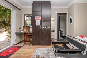 uma sala de estar com uma mesa e uma geladeira em Keiskama B & B em Port Elizabeth