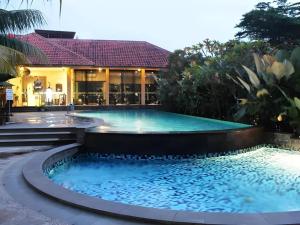 - une piscine en face d'un bâtiment avec une maison dans l'établissement Narita Classic Hotel, à Pesis Empat