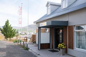 un edificio con una puerta con una bandera. en Hotel West en Patreksfjörður