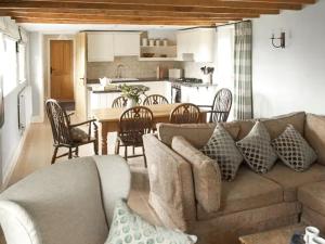 un salon avec un canapé et une table et une cuisine dans l'établissement Fursdon Cottage, à Cadbury
