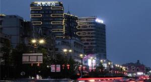 a city street with cars in front of tall buildings at Lavande Hotel Deyang Guanghan in Deyang