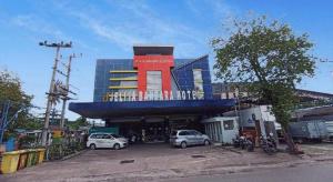 a building with a blue and red building with cars parked in front at Jelita Bandara Hotel Airport in Ulin