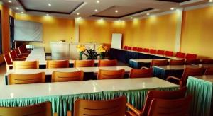 ein Restaurant mit Tischen und Stühlen in einem Raum in der Unterkunft Nikita Palace in Bukittinggi