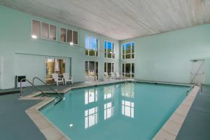 an indoor swimming pool with blue water in a building at Rodeway Inn & Suites Hershey Chocolate Avenue in Hershey