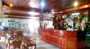 a restaurant with a bar with chairs and a counter at Sisavath Hotel in Ban Houadông
