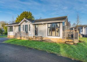 une maison blanche avec un banc dans la cour avant dans l'établissement Cleveland Hills View Holiday Park, à Middleton upon Leven