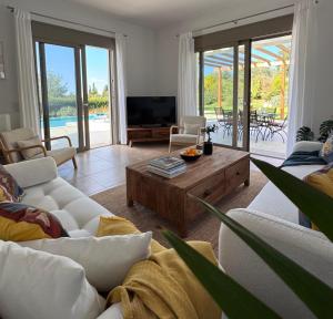 a living room with couches and a television and a table at Villa Paradisio in EFL