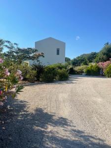 a gravel driveway with a white building in the background at Villa Paradisio in EFL