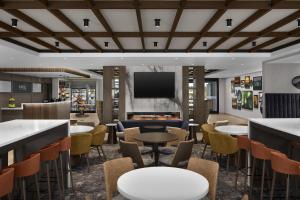 a restaurant with tables and chairs and a flat screen tv at Home2 Suites By Hilton Ramsey in Ramsey