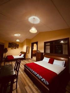 une chambre avec deux lits et une table dans une pièce dans l'établissement Diyon Holiday Bungalow, à Bandarawela