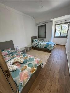 a bedroom with two beds and a flat screen tv at Grand appartement 3 chambres à la résidence valmascort Annaba in Annaba