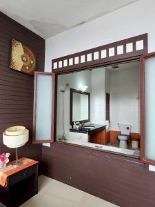 ein Badezimmer mit Toilette, Waschbecken und Spiegel in der Unterkunft The Rest Phuket in Phuket