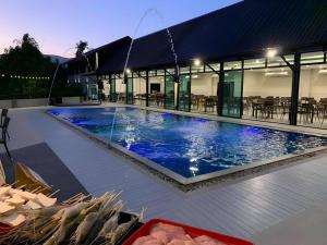 une grande piscine d'eau bleue en face d'un bâtiment dans l'établissement KS HOTEL, à Ban San Ton Kok