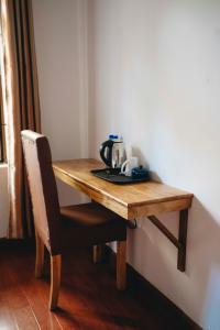 ein Holztisch mit einem Stuhl und einer Teekanne darauf in der Unterkunft Naibor Villa in Themi