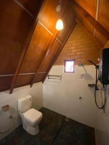 a bathroom with a white toilet in a attic at Green Forrest Cabanas - Ella in Ella