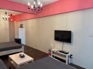 a living room with a flat screen tv on a wall at 海沐輕旅 Sea Mu Kenting in Nanwan