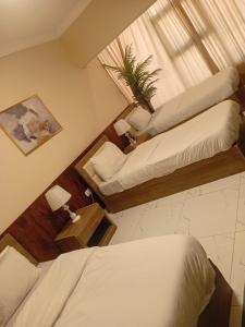 Una habitación de hotel con dos camas y una ventana. en VIPOneAmman, en Amán 3 fotos más