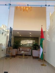 Un vestíbulo con una mesa, sillas y una bandera en VIPOneAmman, en Amán