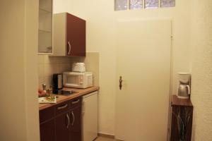 eine Küche mit einer weißen Tür und einer Mikrowelle in der Unterkunft Apartment Inzersdorferstraße in Wien