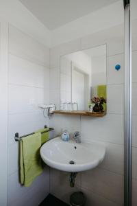 um banheiro branco com uma pia e um espelho em Sonnenweg Appartements em Rust