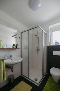 um banheiro com chuveiro, pia e vaso sanitário em Sonnenweg Appartements em Rust