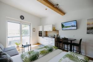 uma sala de estar com um sofá branco e uma cozinha em Sonnenweg Appartements em Rust