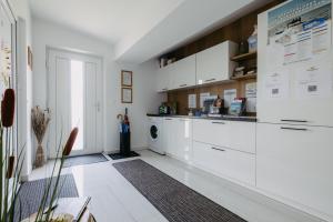 a kitchen with white cabinets and a dishwasher at Sonnenweg Appartements in Rust