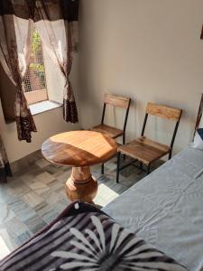une pièce avec deux chaises, une table et un lit dans l'établissement guest house UGS, à Jodhpur