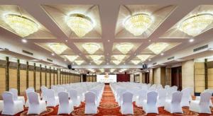 Cette grande chambre comprend des chaises blanches et un écran de projection. dans l'établissement New Century Hotel Nanjing, à Pukou 233 autres photos