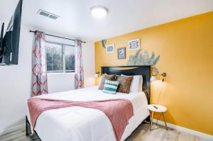 盐湖城Luxury Downtown SLC Retreat, King Bed 2 Bed 1 Bath的卧室里有一张床和一面黄色的墙