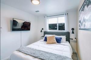 盐湖城Exclusive Downtown SLC Spot, King Bed 2 Bed 1 Bath的一间卧室，有一张白色的床和一扇窗户