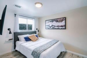 盐湖城Exclusive Downtown SLC Spot, King Bed 2 Bed 1 Bath的卧室里有一张白色的大床，床边有一扇窗户