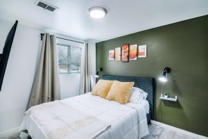 une chambre avec un lit blanc et un mur vert dans l'établissement Spacious Downtown SLC, Cozy King Bed 2 Bed 1 Bath, à Salt Lake City