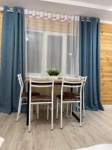 a dining room table and chairs with blue curtains at Hotel ATAUUL in Kaji-Say