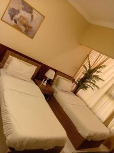 Dos camas en una habitación con ventana. en VIPOneAmman, en Amán