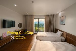 una camera d'albergo con due letti e una tv di Luxury 88 Hotel a Phủ Lý
