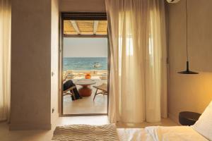 a bedroom with a view of the ocean at Beau Rivage Suites in Lóngos