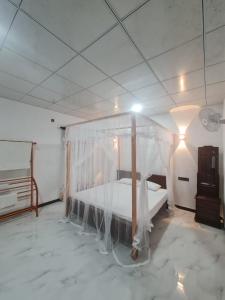 a bedroom with a bed with a mosquito net at Frida Cove in Weligama