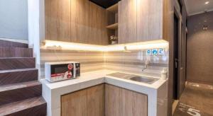 eine kleine Küche mit Spüle und Mikrowelle in der Unterkunft OYO Life 3246 Walnut Inn G-10 in Telukjambe