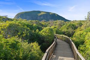 Acacia - Mount Coolum 3BD Townhouse في Yaroomba: ممشى خشبي يؤدي إلى جبل في المسافة