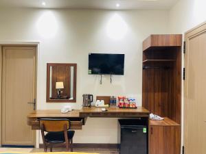 a hotel room with a desk and a television on the wall at King Sea Hotel in Rạch Giá