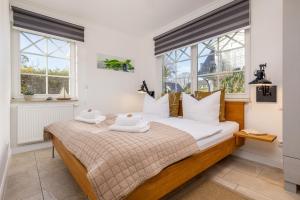 a bedroom with a bed with two towels on it at Whg Dynamique in Zingst