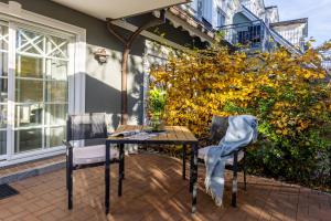 a patio with a table and two chairs and a plant at Whg Dynamique in Zingst
