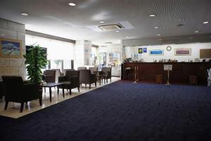a lobby with a waiting room with tables and chairs at Mizue Dai-ichi Hotel in Tokyo