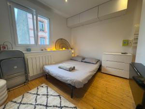 une petite chambre avec un lit et une fenêtre dans l'établissement Le Coty, au Havre