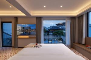 a bedroom with a large bed and a large window at Palace House Guangzhou Yongqingfang Moon Bridge Store in Guangzhou