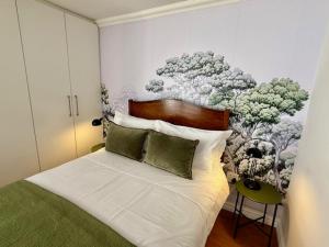 een slaapkamer met een bed met een schilderij aan de muur bij The Sultan Cottage in Stellenbosch