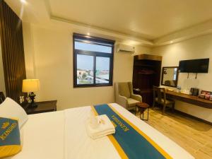 a hotel room with a bed and a desk at King Sea Hotel in Rạch Giá
