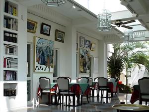 ein Esszimmer mit einem Tisch, Stühlen und Bücherregalen in der Unterkunft Arabian Art Hotel & Gallery in Kawaguchi