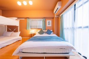 綺麗に改装されたアパートメント 京都や新大阪駅へアクセス良好 3ベッド 1バスルーム في أوساكا: غرفة نوم بها سريرين ونافذة كبيرة